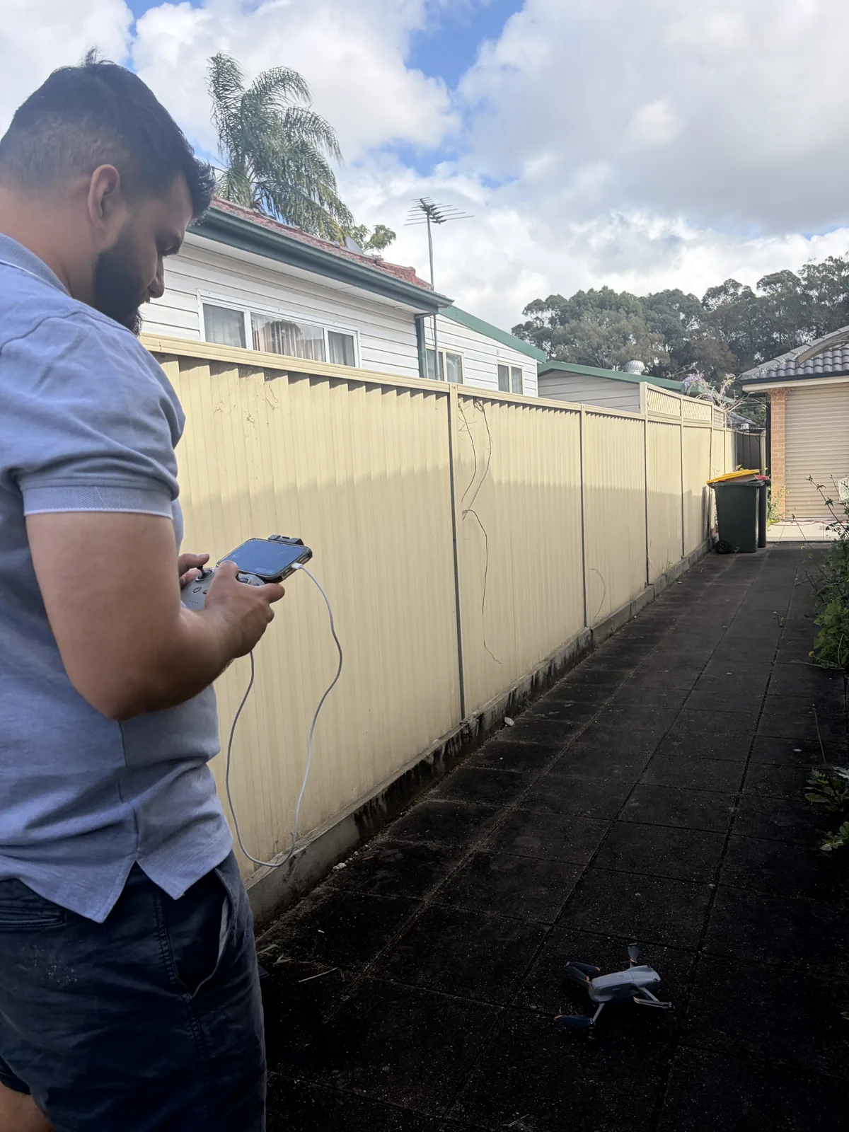 Ibrahim flying the inspection drone beside a house